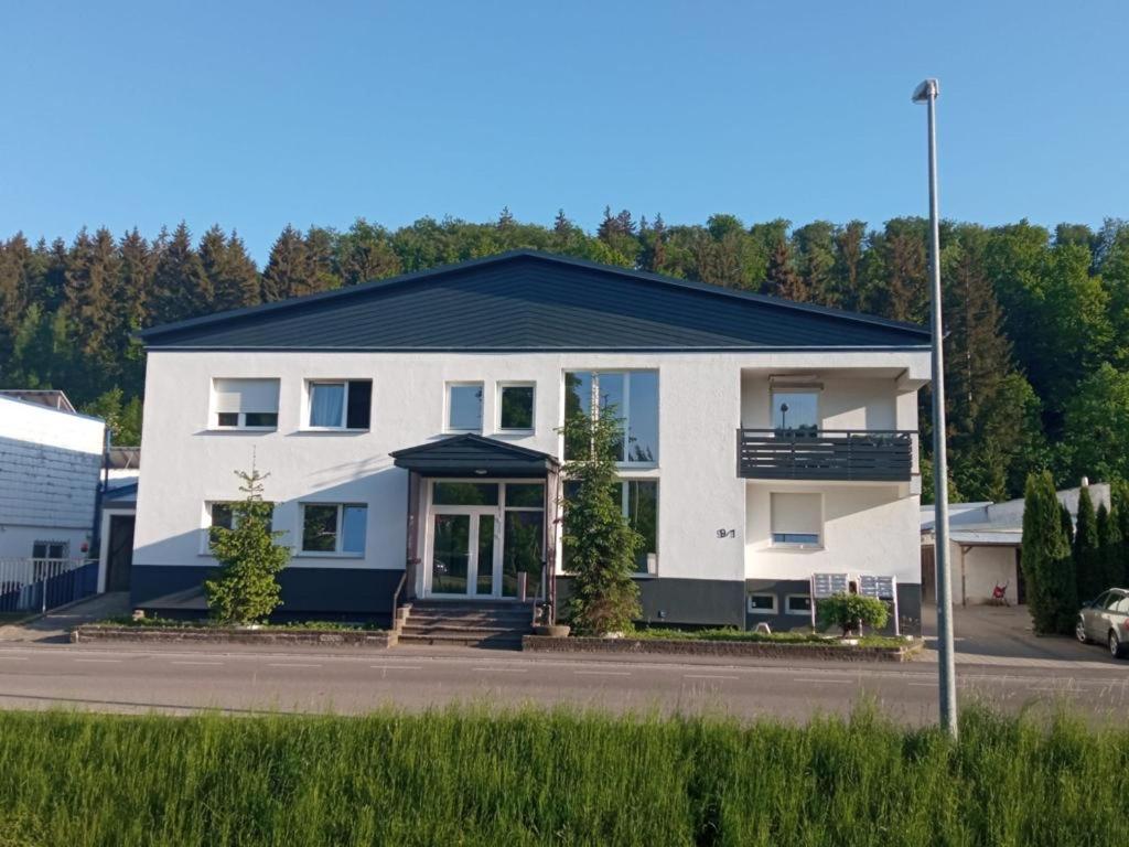 a large white house with a black roof at Heidenheimer Zimmer in Heidenheim an der Brenz