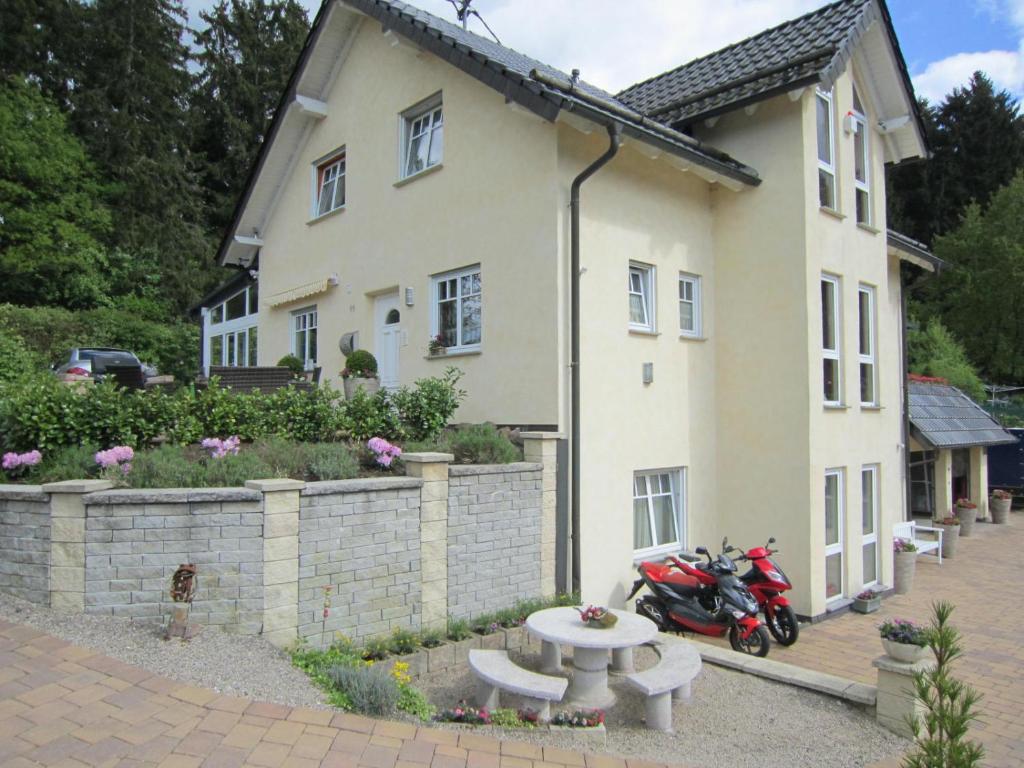 ein Haus mit einem Motorrad, das davor geparkt ist in der Unterkunft Gästehaus Dobias in Kelberg