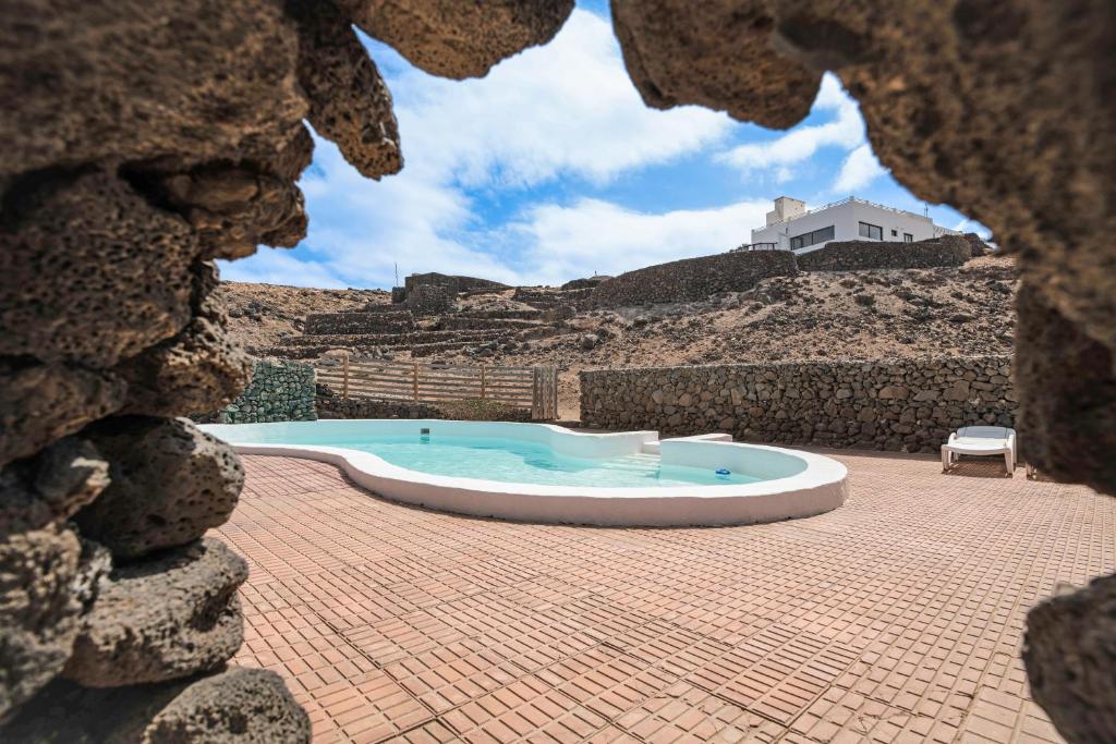 a view of a swimming pool from a hole in a rock at Playa Marina Eco Bungalow Mala in Arrieta