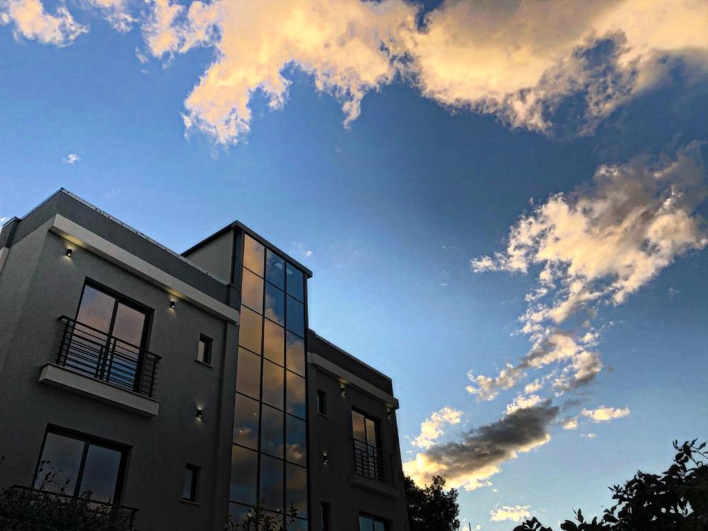un edificio con un cielo nublado detrás de él en Rittson - Boutique Hotel en Vlorë