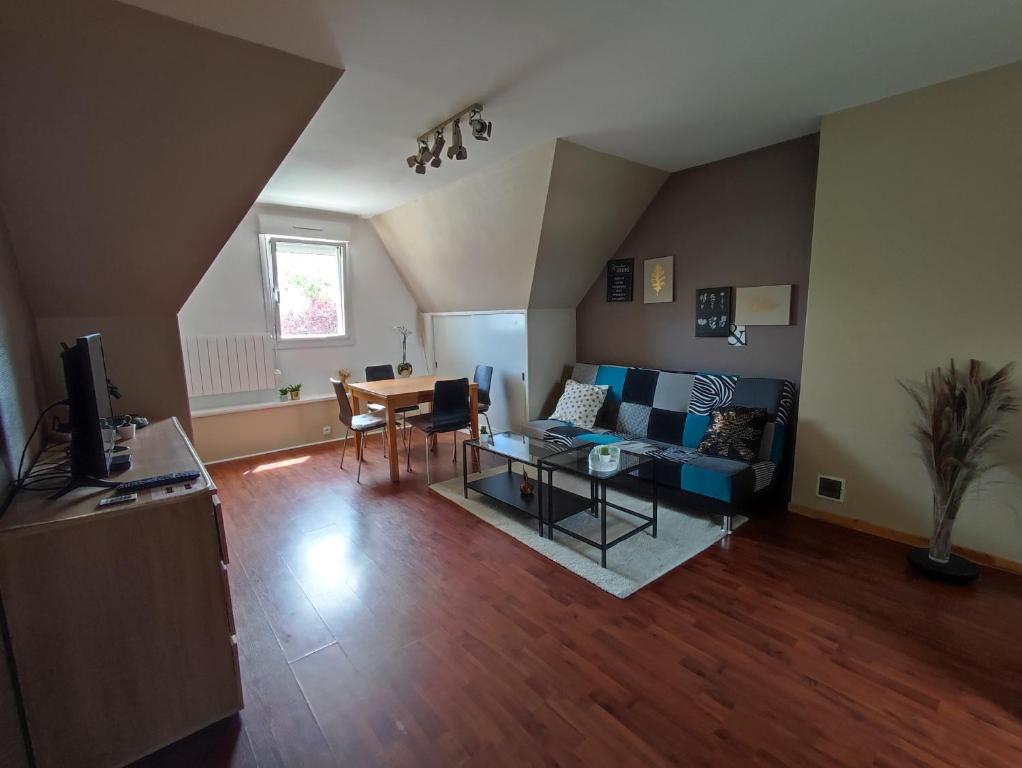 a living room with a couch and a table at Appartement calme aux portes de Rennes in Vezin-le-Coquet