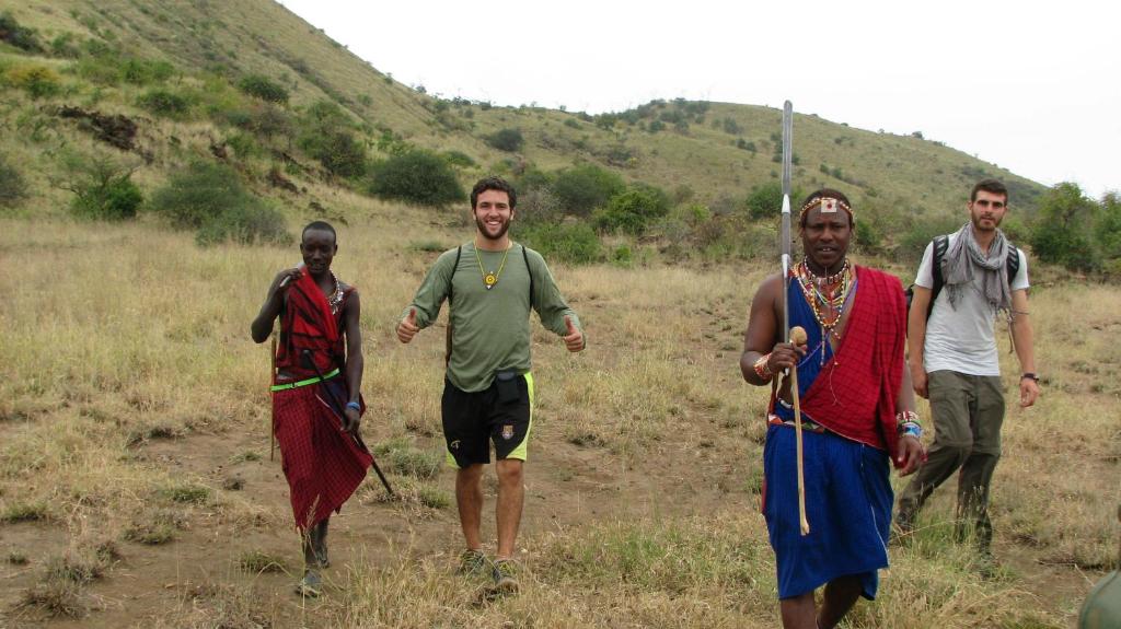 a group of men walking in a field at Maasai Simba Camp in Amboseli