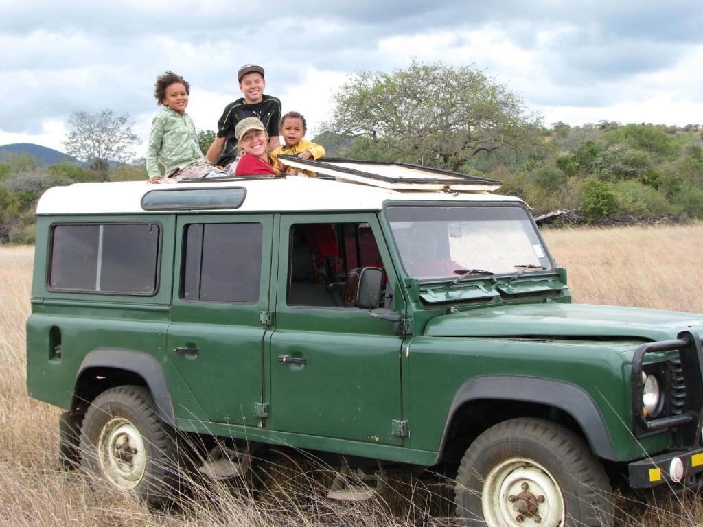 three children sitting on top of a green jeep at Maasai Simba Camp in Amboseli