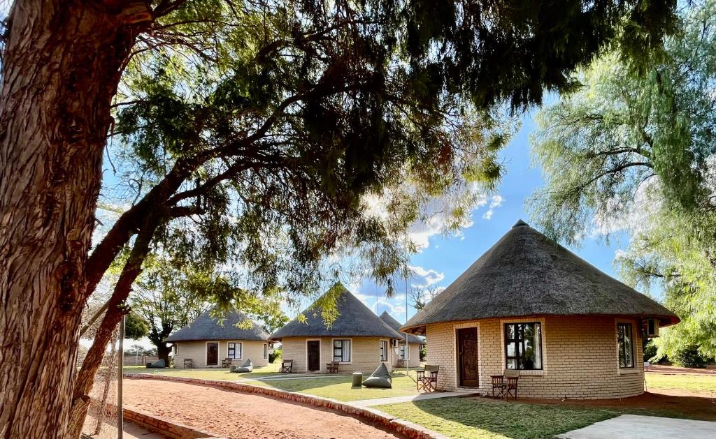 a house with a thatched roof in a park at Gamagara Africa Private Nature Reserve in Kathu