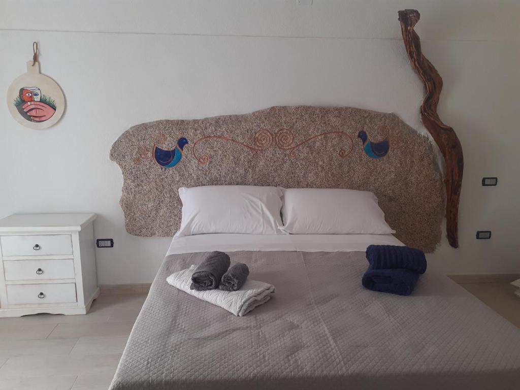 uma cama com dois pares de sapatos sentados nela em bed and breakfast Murales Orgosolo em Orgosolo