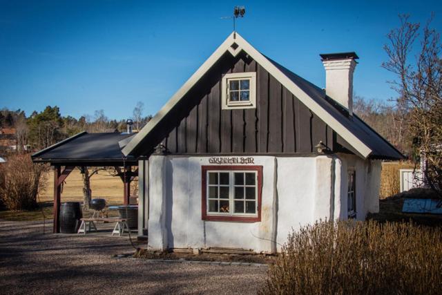 una pequeña casa en blanco y negro en Grynnan, en Skå