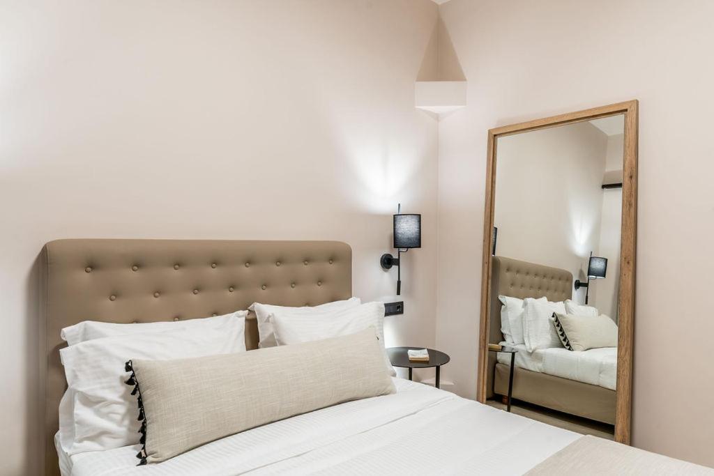 sypialnia z białym łóżkiem i lustrem w obiekcie Hotel Eucalyptus w mieście Mesaria