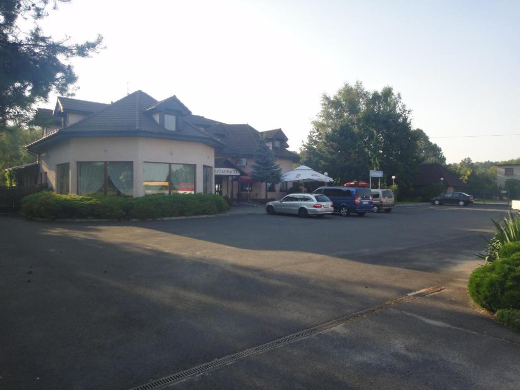 a house with a car parked in a parking lot at Zajazd Adampol in Strumień