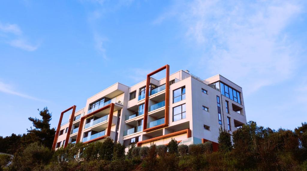 un bâtiment blanc au sommet d'une colline dans l'établissement Silba - Luxury Apartment, à Rabac
