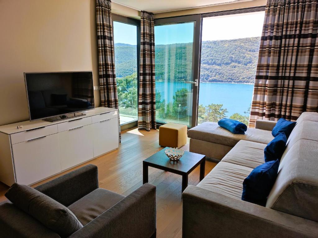 a living room with couches and a large window at Silba - Luxury Apartment in Rabac