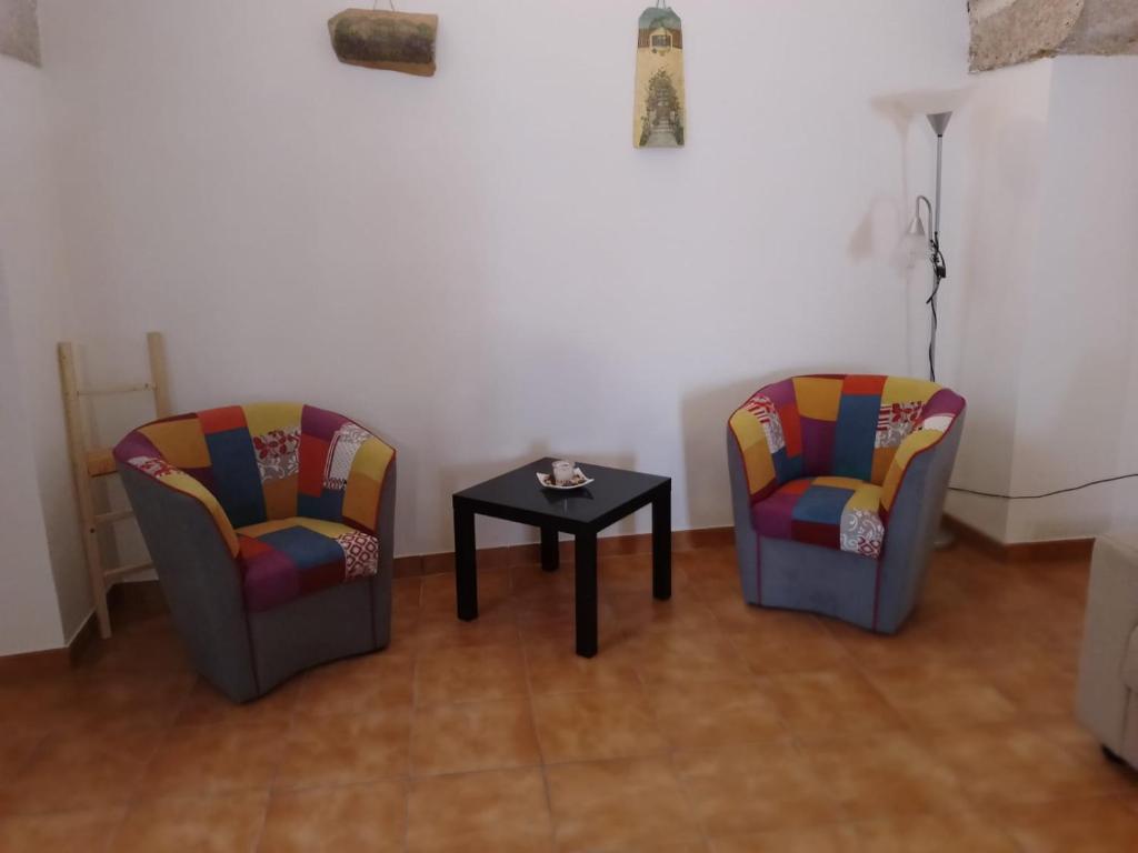 duas cadeiras e uma mesa num quarto em B&B La volta di Fabio De Marco e Simona Saracino em San Pietro Vernotico