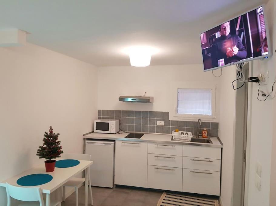 eine Küche mit einem Tisch und einem TV an der Wand in der Unterkunft center Mestre 15 minutes from Venice, parking Bellini in Mestre