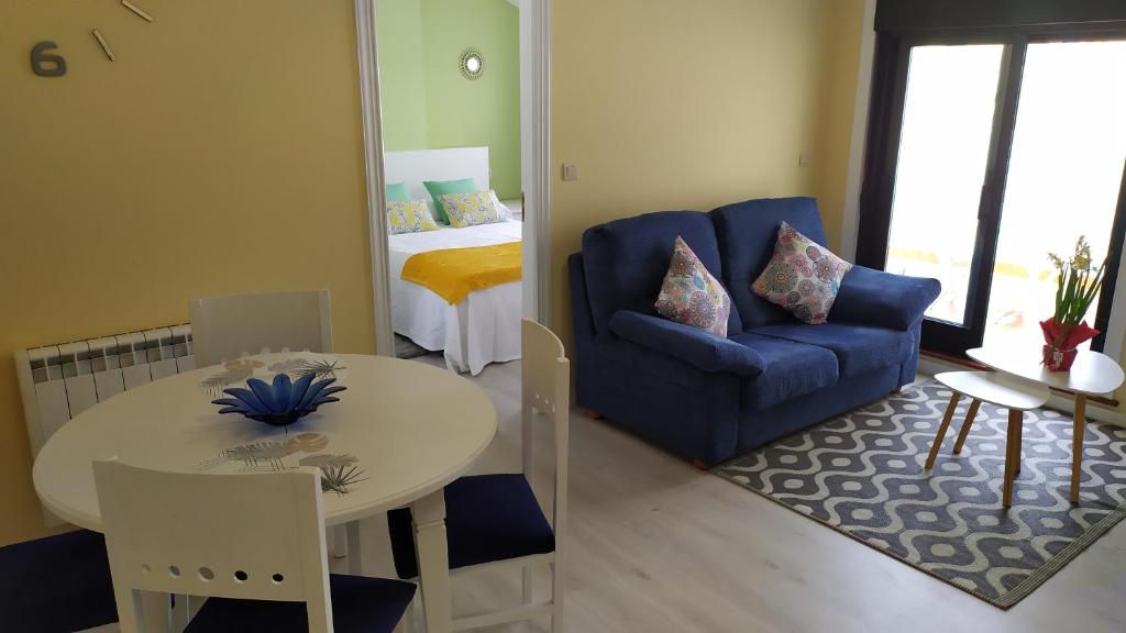 Rua GALICIA في أغواردا: غرفة معيشة مع أريكة زرقاء وطاولة