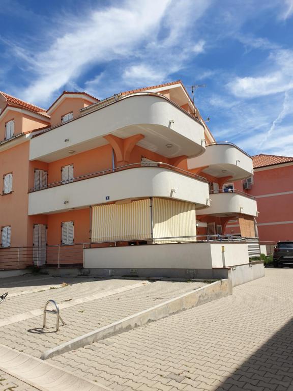 un edificio con un edificio blanco y naranja en Sunrise apartment, en Povljana