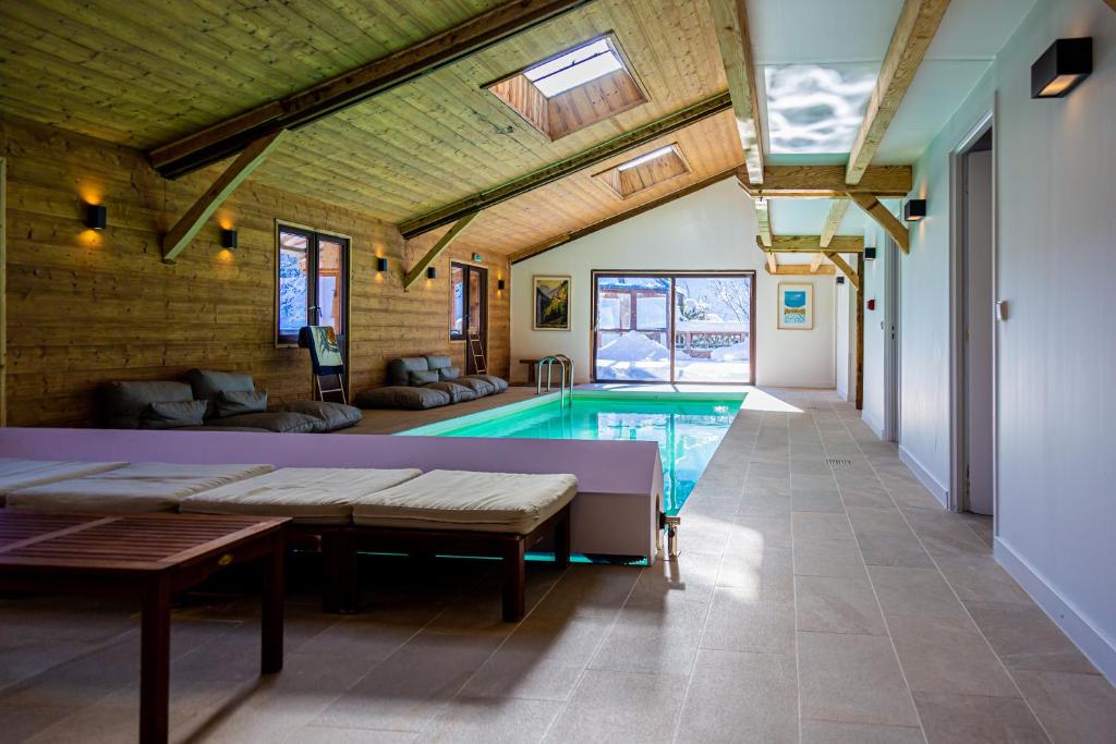 uma sala de estar com piscina numa casa em Grand chalet convivial avec sa piscine intérieure em Serraval