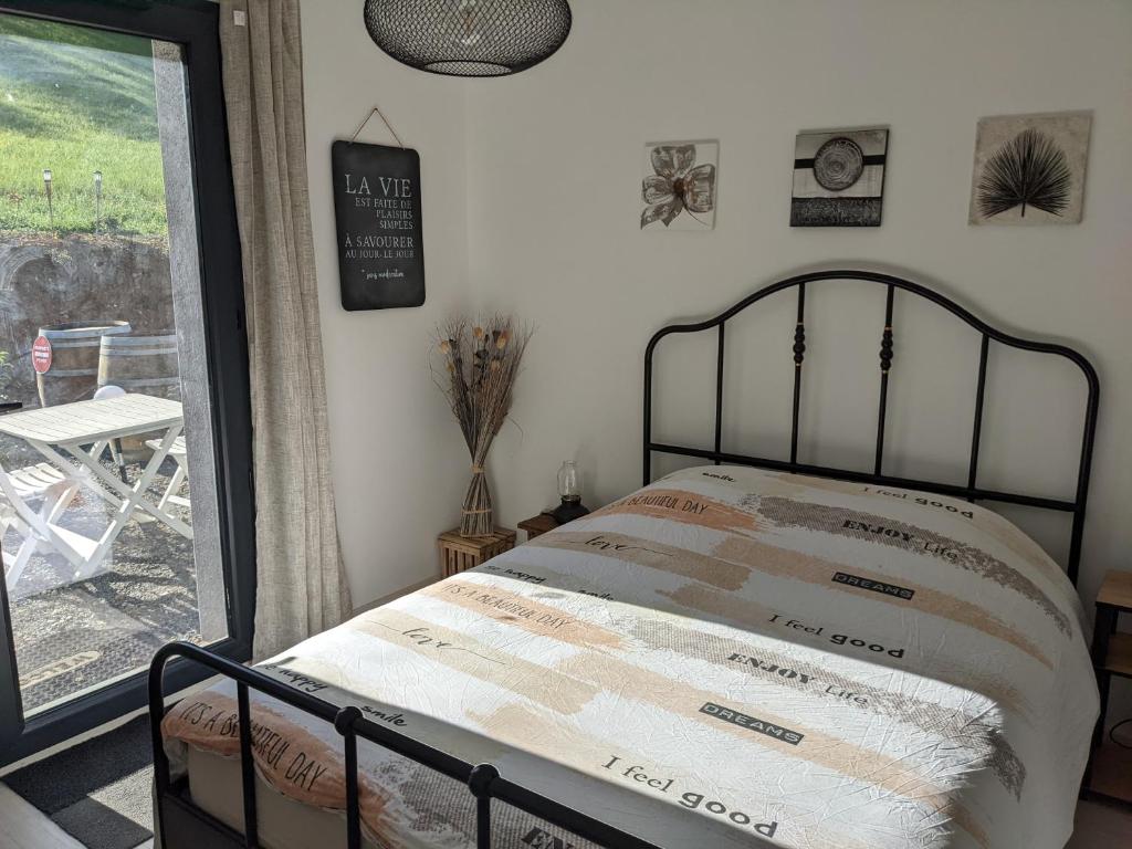 ein Schlafzimmer mit einem Bett und ein Fenster mit einer Terrasse in der Unterkunft Chambre double indépendante NATURALE au sein du domaine PASSELOUP in Liergues