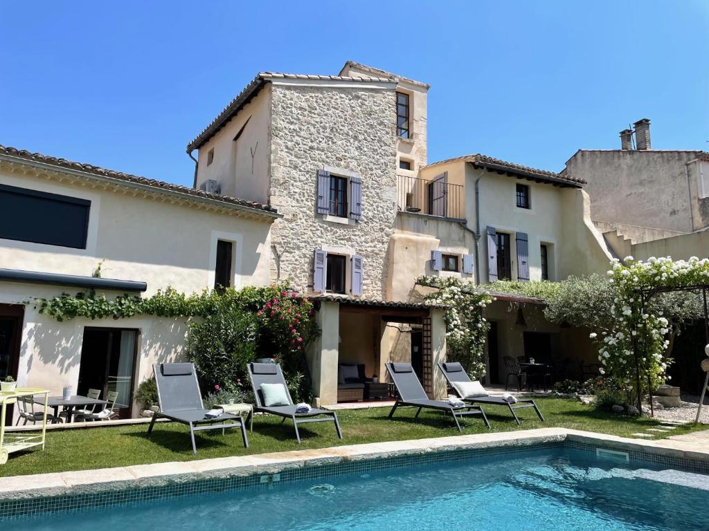 une villa avec une piscine en face d'un bâtiment dans l'établissement B&B Temps Suspendu Provence, à Pernes-les-Fontaines