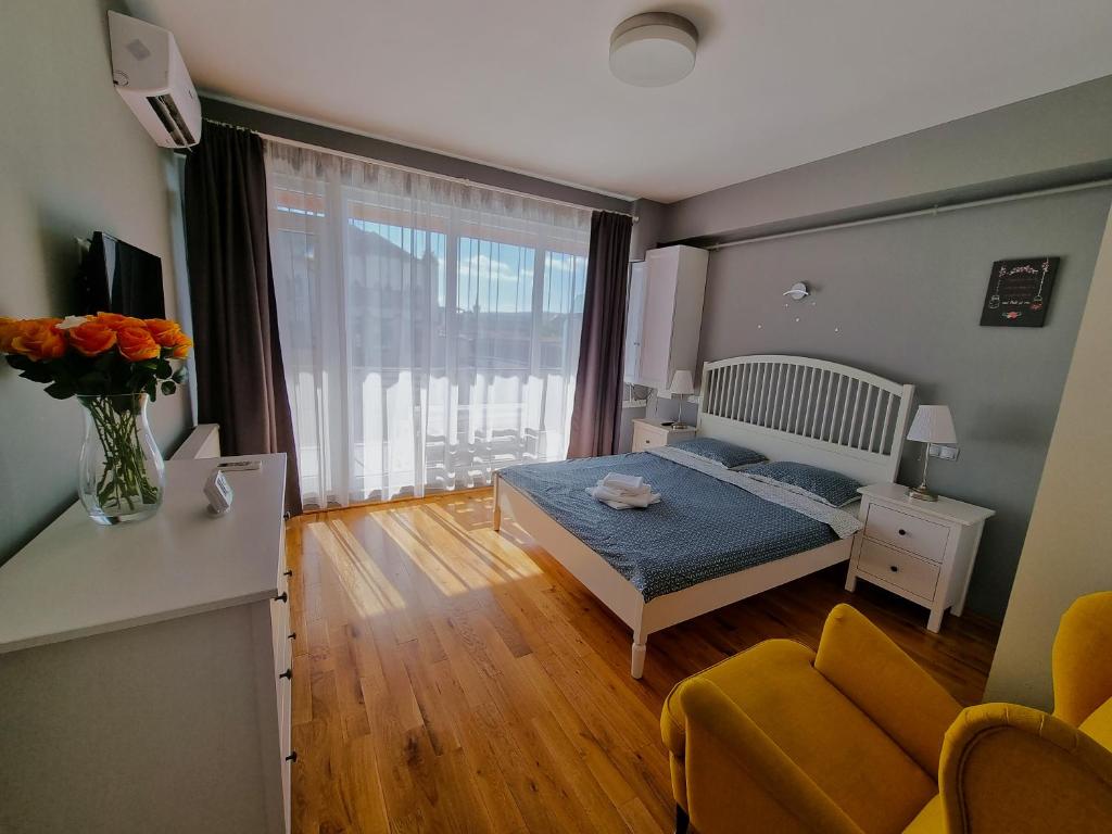 a bedroom with a bed and a couch and a window at Traian Apartment - Cluj in Cluj-Napoca