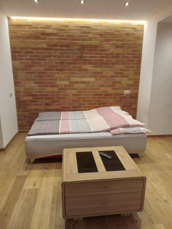 1 dormitorio con cama y pared de ladrillo en MIKAS HAUS, en Bad Aussee