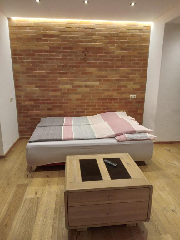 a bedroom with a bed and a brick wall at MIKAS HAUS in Bad Aussee