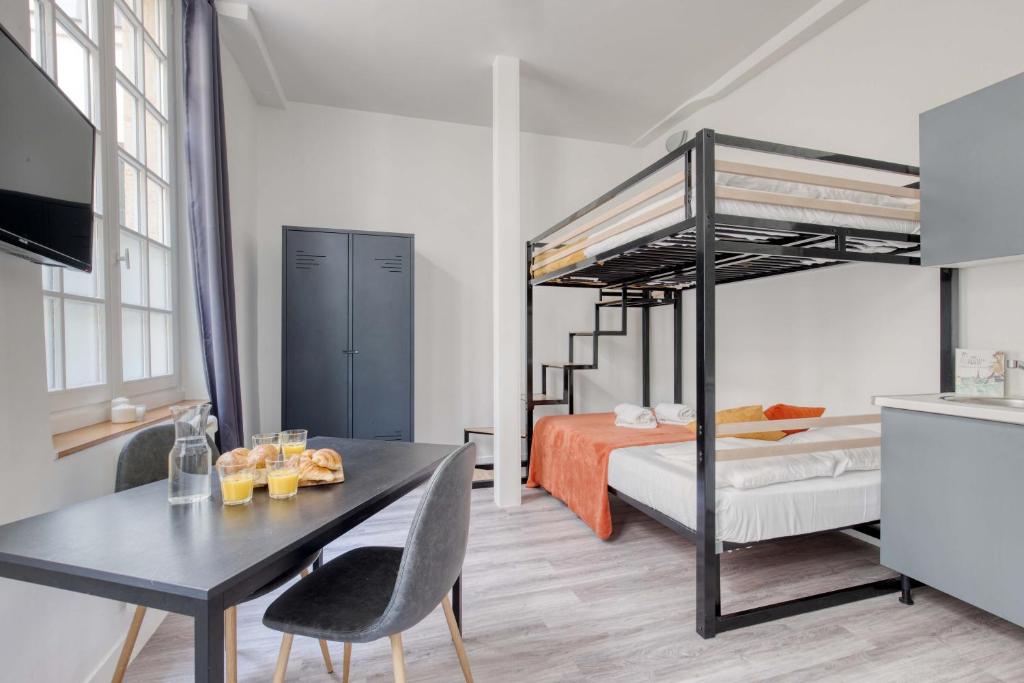 ein Schlafzimmer mit einem Etagenbett und einem Esstisch in der Unterkunft New & Design Studios in the Heart of Le Marais in Paris