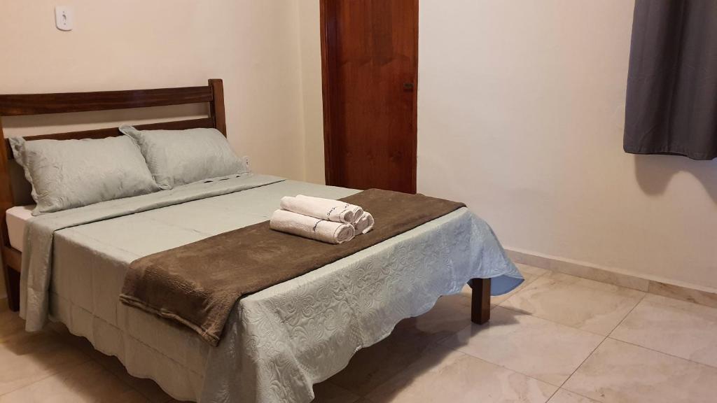 ein Schlafzimmer mit einem Bett mit zwei Handtüchern darauf in der Unterkunft Pousada São José in Guaratinguetá