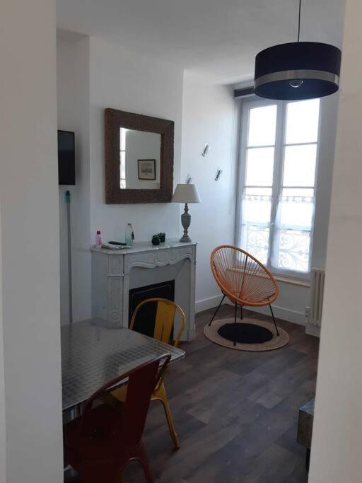 un salon avec une table et des chaises et une cheminée dans l'établissement L'albâtre, à Saint-Valery-en-Caux