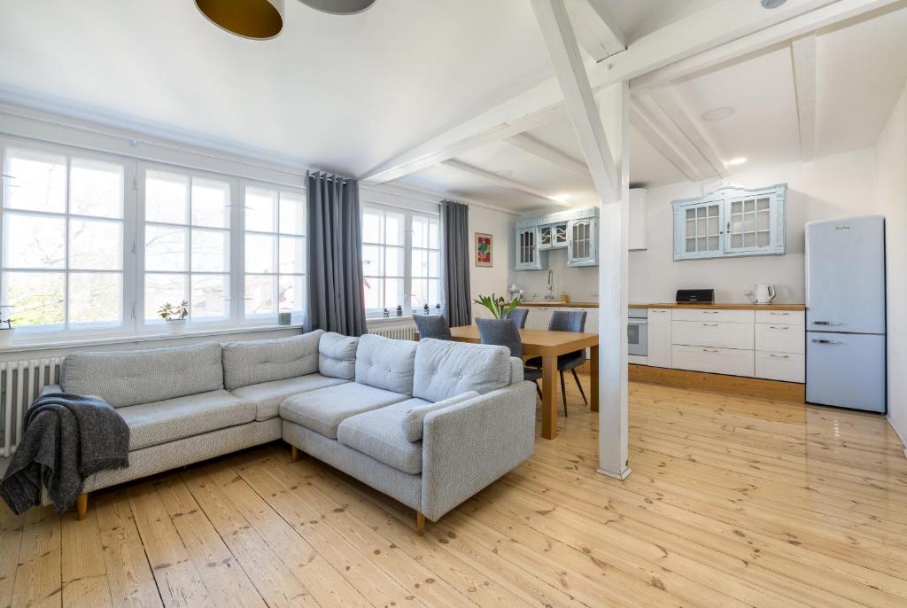 a living room with a couch and a kitchen at Studio Vintage na Kamiennej Górze in Gdynia