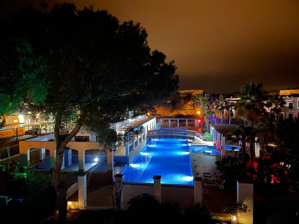 uitzicht op een zwembad in de nacht bij Residencia Cala Dorada in Portopetro