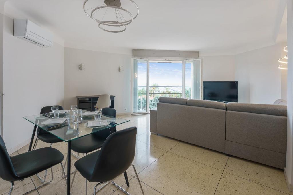 salon ze stołem i kanapą w obiekcie Appartement de Madrid - Welkeys w Cannes