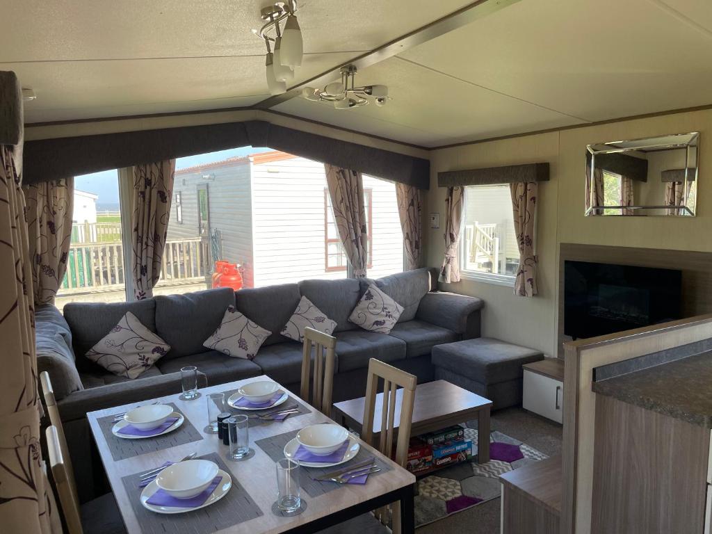 een woonkamer met een tafel en een bank bij PK Holiday Home in Great Yarmouth