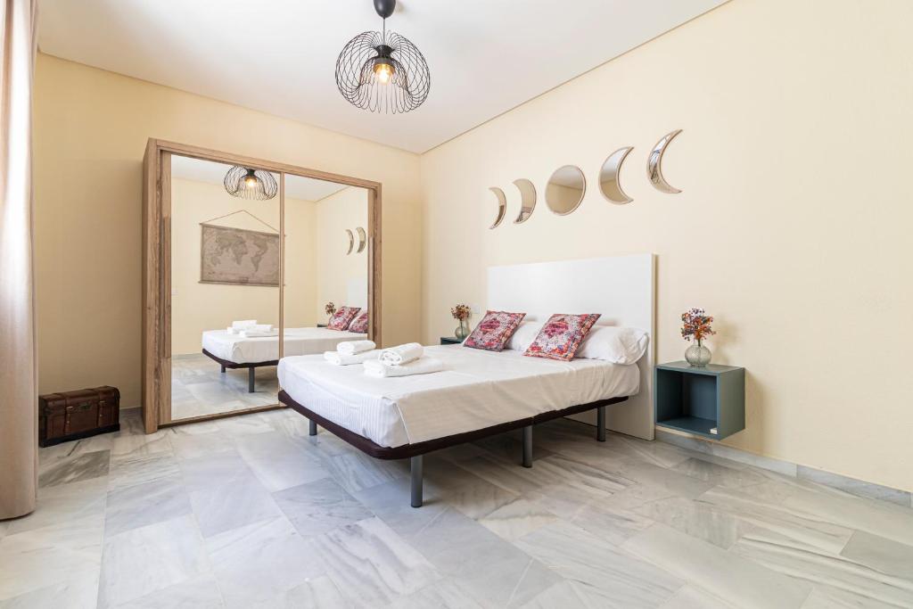 1 dormitorio con 2 camas y un espejo grande en Allo Apartments Caballeros Centro 2 Habitaciones, en Jerez de la Frontera