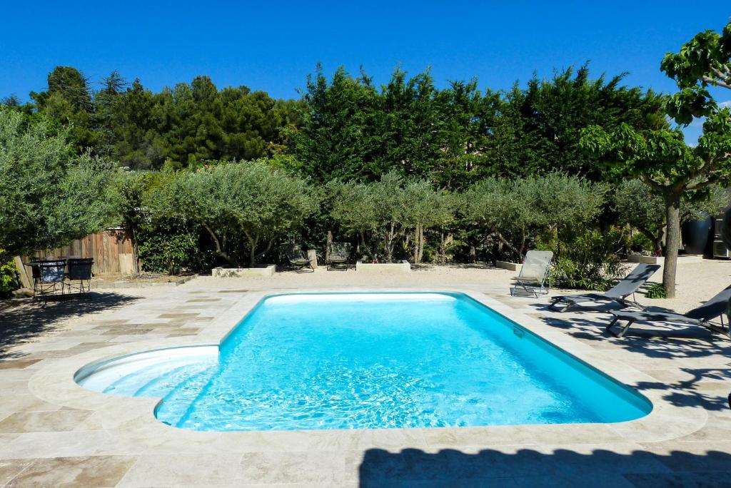 una piscina en un patio con árboles en L'Atelier d'André, en Beaumes-de-Venise