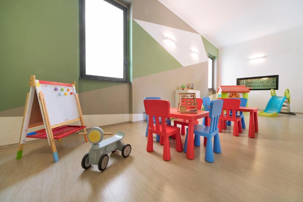 pokój zabaw z kolorowymi krzesłami i stołem w obiekcie Hotel Residence Laigueglia w mieście Laigueglia