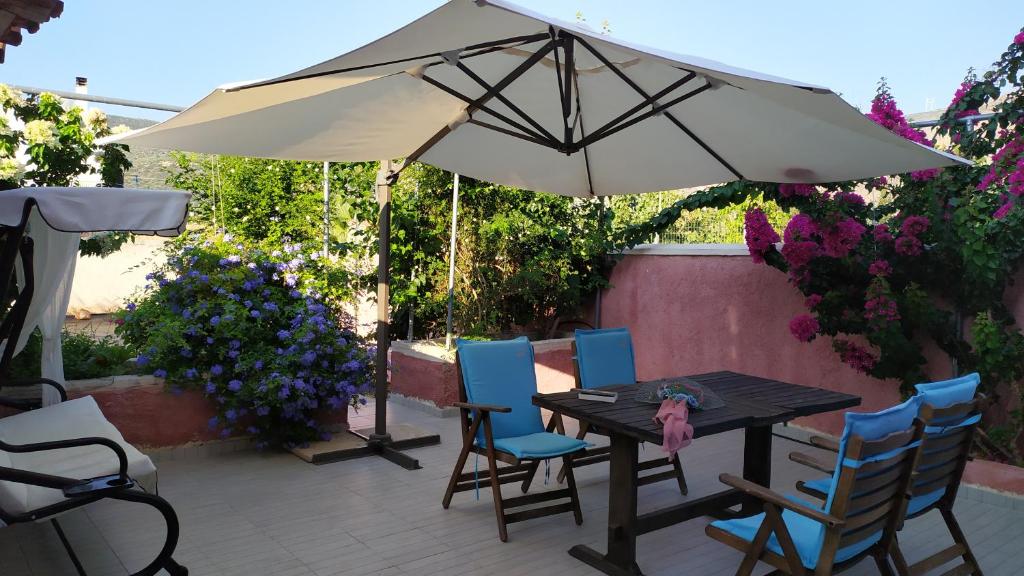 een tafel en stoelen onder een parasol op een patio bij LocriHOUSE-Stylish comfortable home in Galaxidi in Galaxidhion