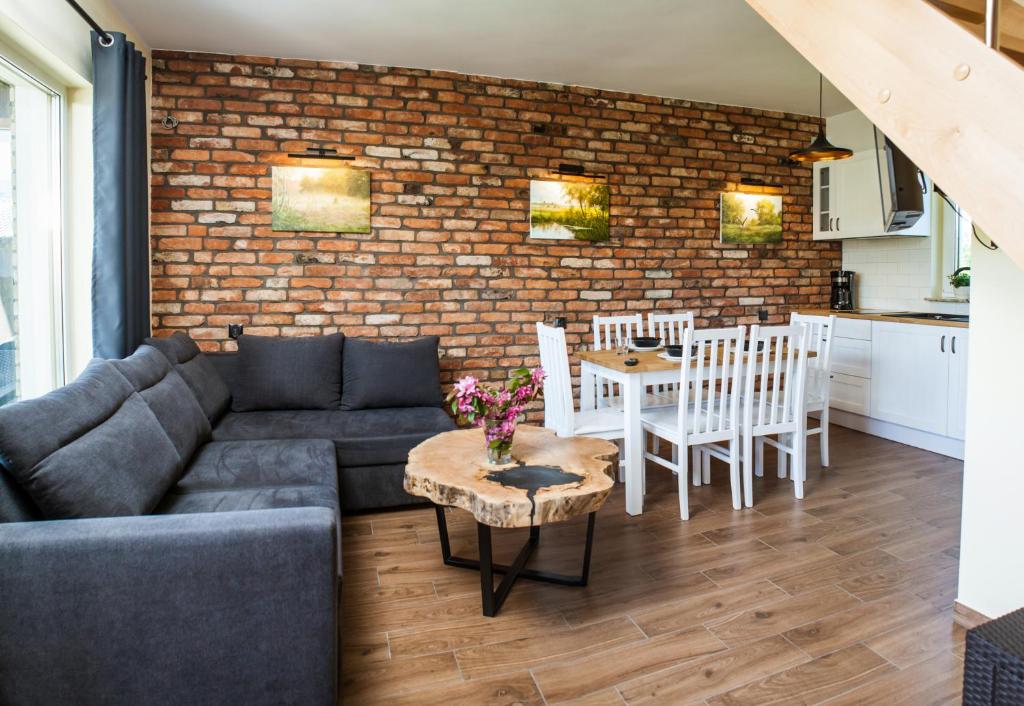 a living room with a couch and a brick wall at Domki Nordic in Władysławowo