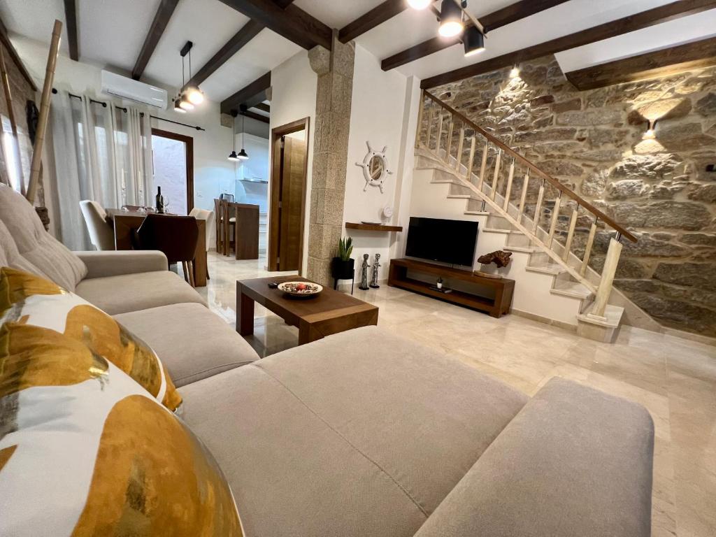 a living room with couches and a stone wall at Preciosa casa marinera en Carril in Vilagarcia de Arousa