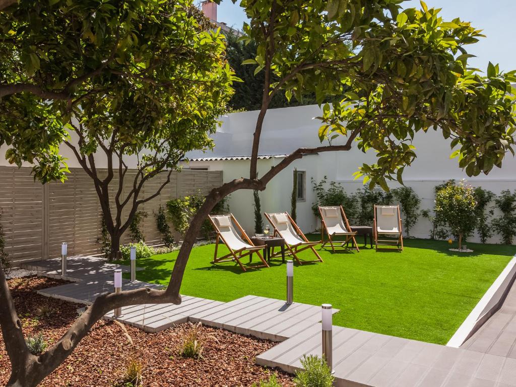 d'un jardin avec des chaises, une table et de la pelouse. dans l'établissement Vila Garden Guesthouse, à Lisbonne