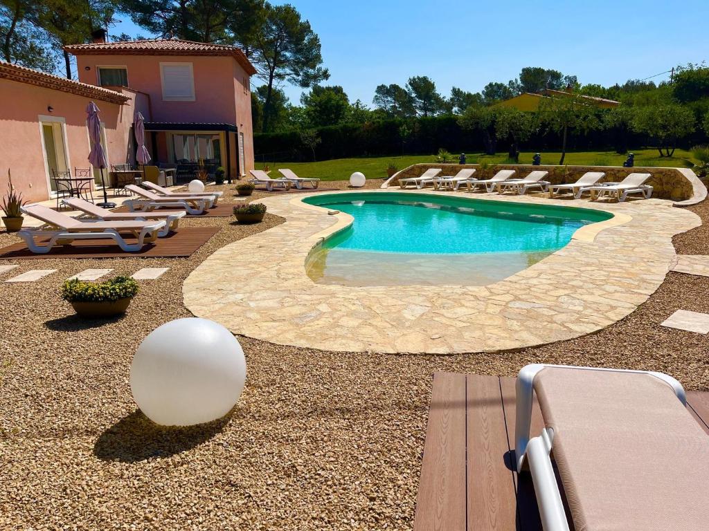 a swimming pool with lounge chairs and a resort at Domaine Le Mas Sans Soucis in Fayence