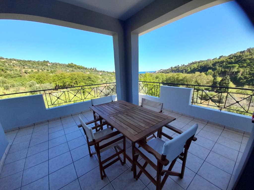 a dining room with a table and chairs on a balcony at View house, Platana Kymi Evoia in Platána