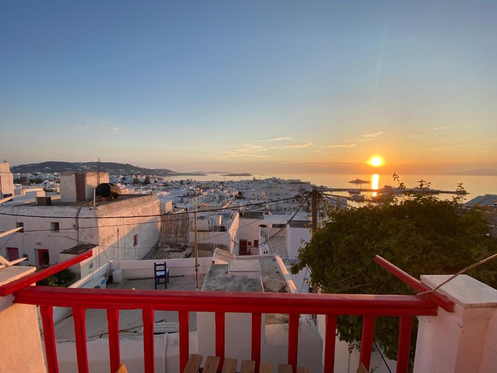 a view of a city at sunset from a balcony at Elenitas Town house with Balcony and Sea View in Mikonos