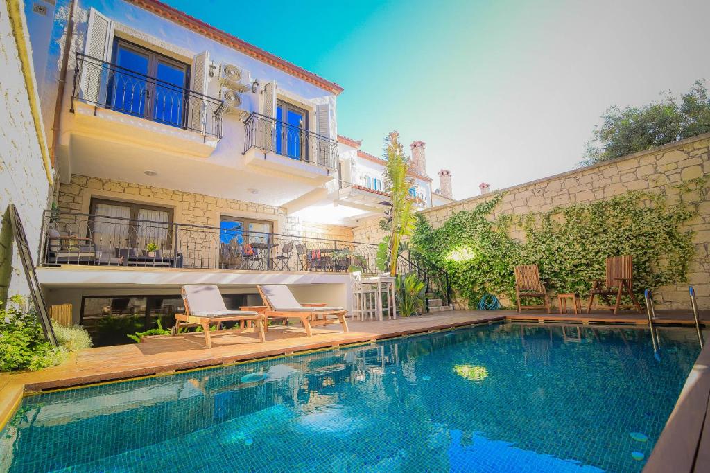 a house with a swimming pool in front of a building at 9 Alacati Boutique Hotel in Alaçatı