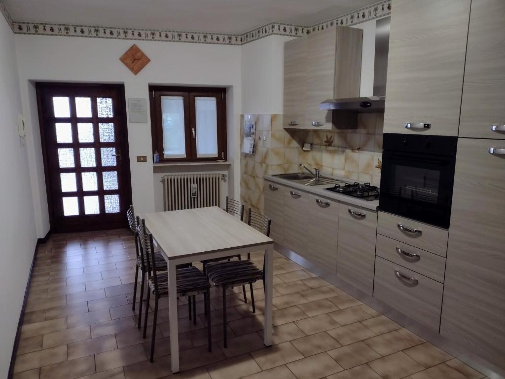 a kitchen with a table and chairs and a stove at Appartamento Teoperga in Sotto il Monte