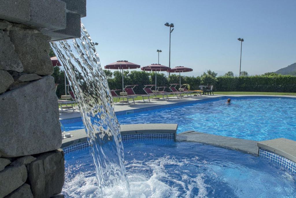 a large swimming pool with a water fountain at Park Hotel La Pineta in Mulazzo