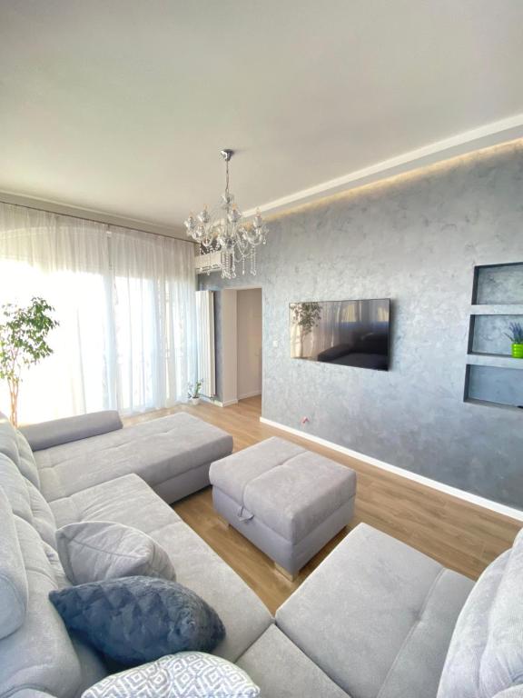 een woonkamer met een bank en een kroonluchter bij Apartment Lana in Baška Voda