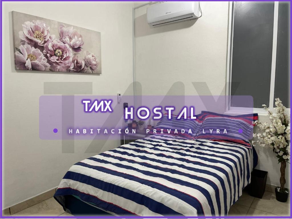 - une chambre avec un lit et une photo de fleurs dans l'établissement TMX HOSTAL, à Puerto Escondido