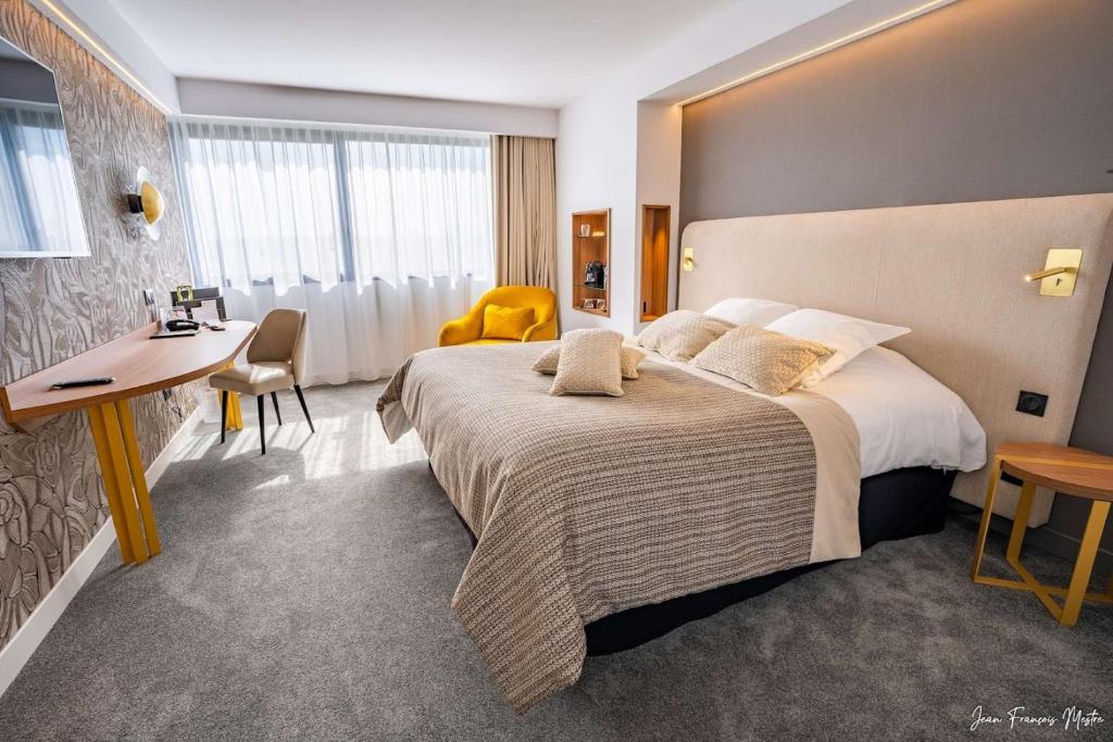una camera d'albergo con un grande letto e una scrivania di Best Western Plus Metz Technopole a Metz