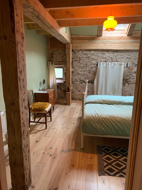 a bedroom with a bed and a stone wall at B & B Maison Helise in La Croix-aux-Mines