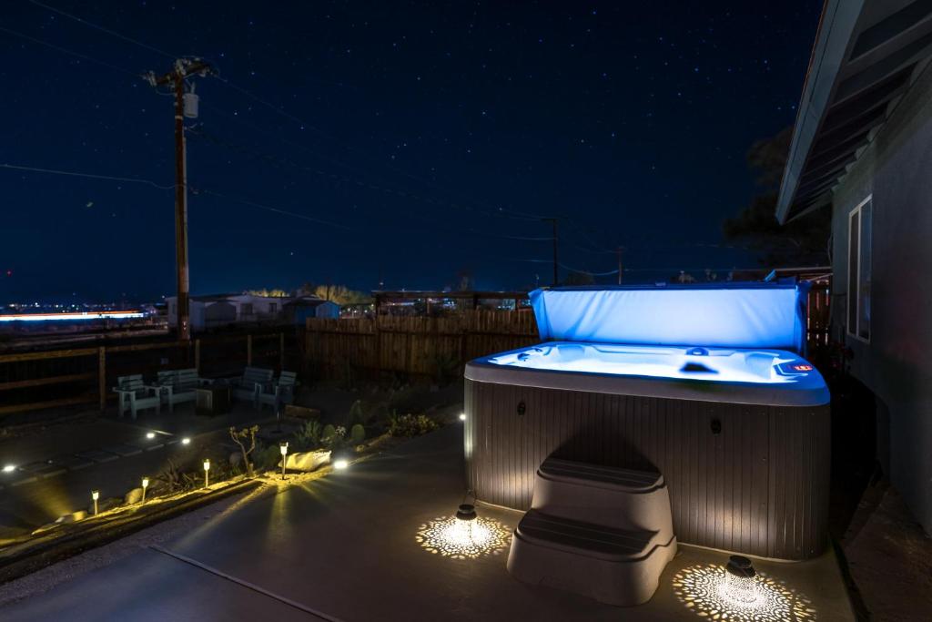 bañera de hidromasaje en el patio por la noche en Desert Twilight 29 - Hot Tub & EV Charger, en Twentynine Palms