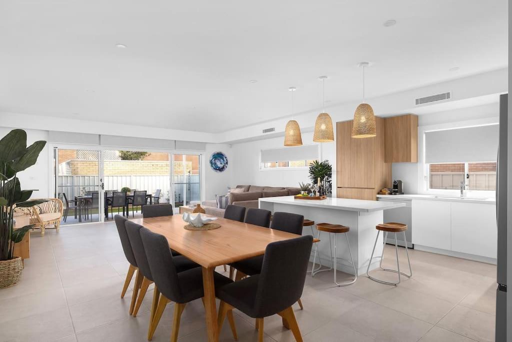 a kitchen and dining room with a wooden table and chairs at HideAwayII at Shoal Bay in Shoal Bay